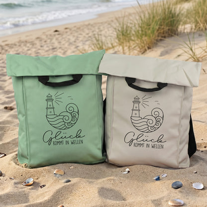 Jadegrüner und beiger Rucksack mit maritimem Leuchtturm Motiv am Strand als Tasche für Urlaub und Ausflug