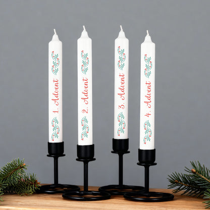 Adventskerzen-Set in schwarzen Kerzenhaltern, weiße Stabkerzen mit Zweigmotiv und Beschriftung 1.–4. Advent vor grauem Hintergrund.