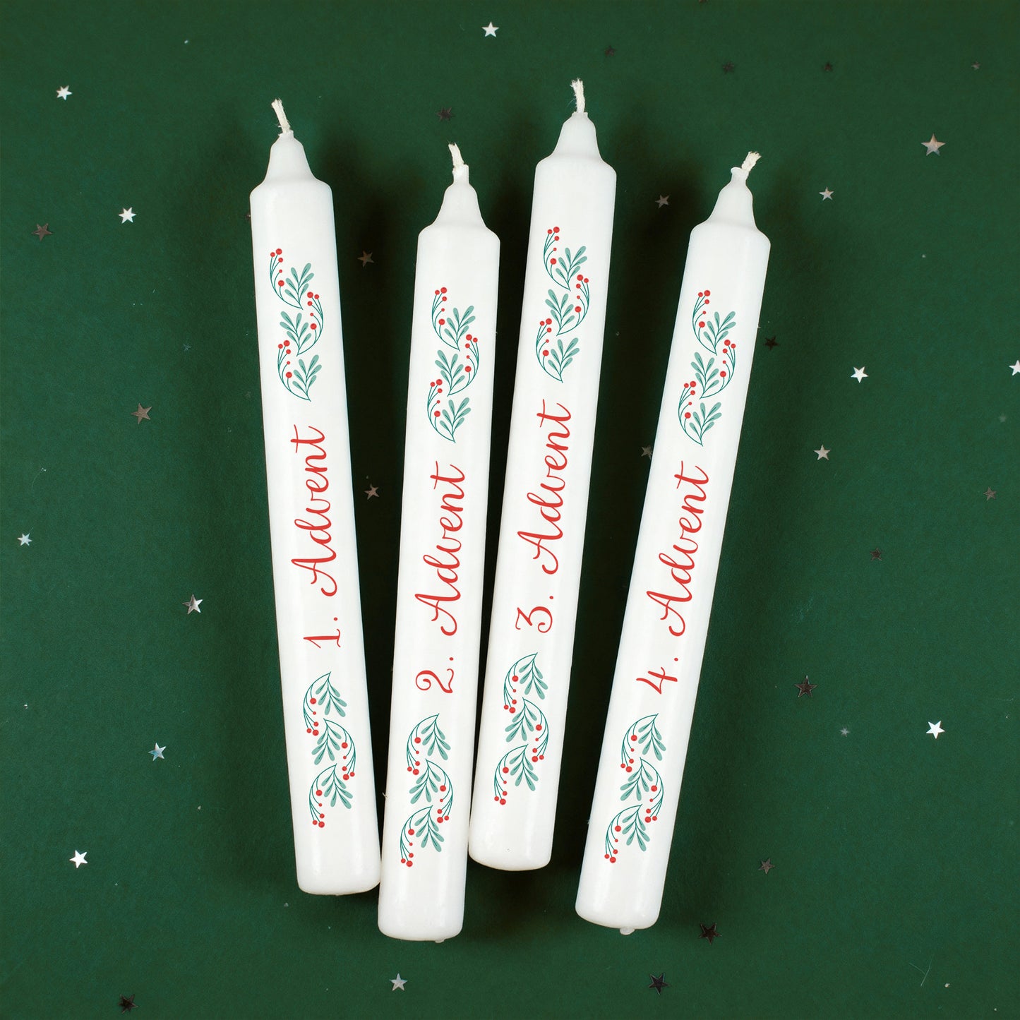 Vier Adventskerzen mit grün-rotem Zweigdesign und Adventszahlen auf grünem Hintergrund mit kleinen Sternen.