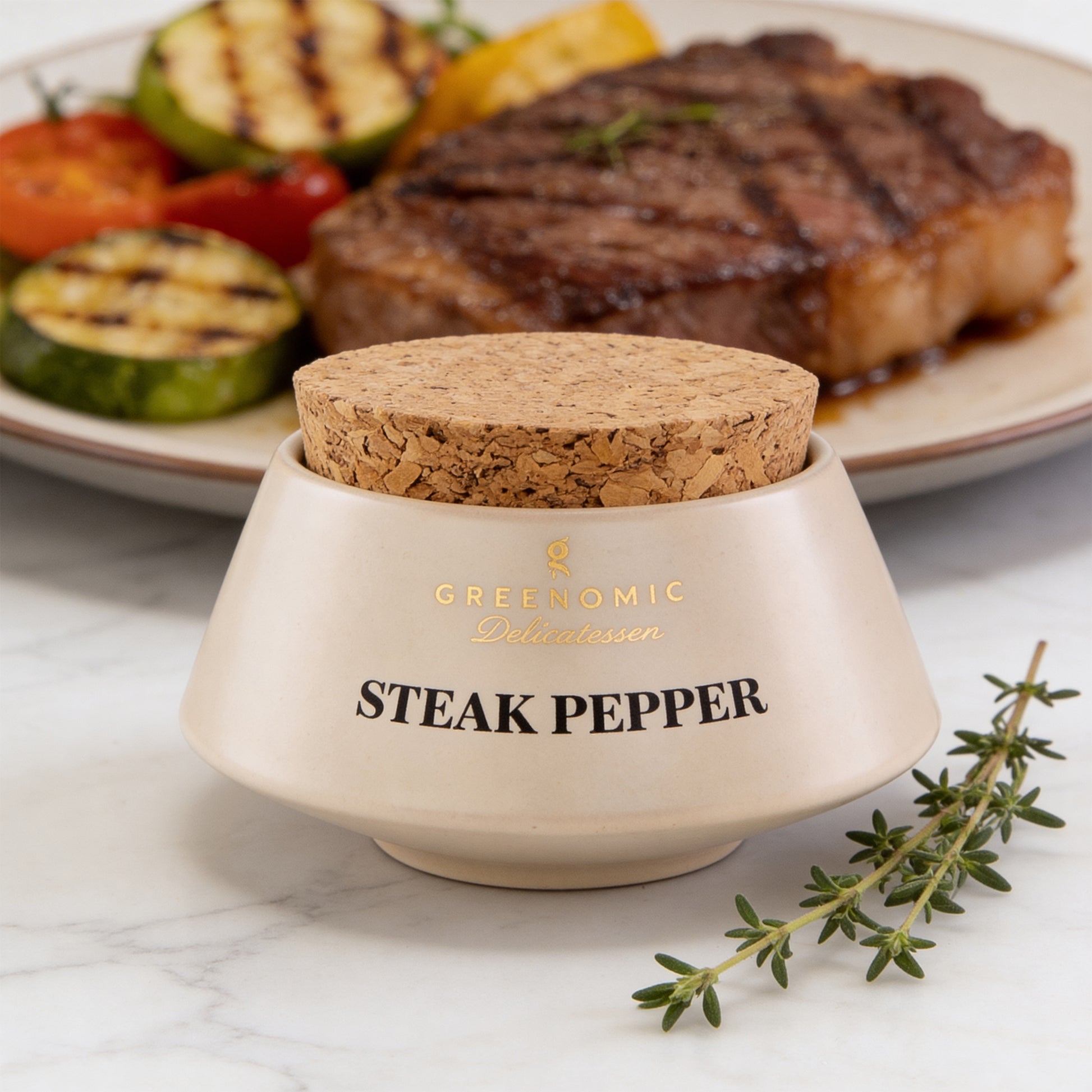Steak Pepper von Greenomic vor gegrilltem Steak mit Gemüse und frischem Thymian