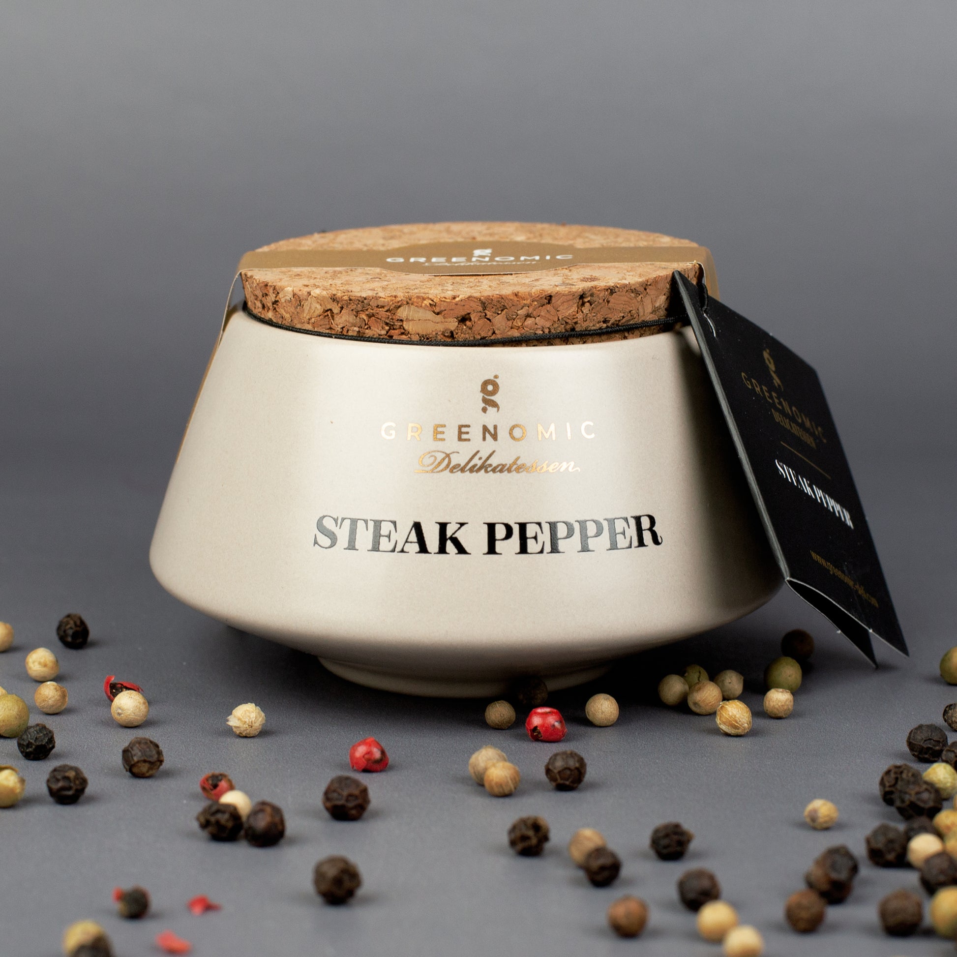 Greenomic Steak Pepper im Keramiktopf mit Korkdeckel und Pfefferkörnern auf dunklem Hintergrund