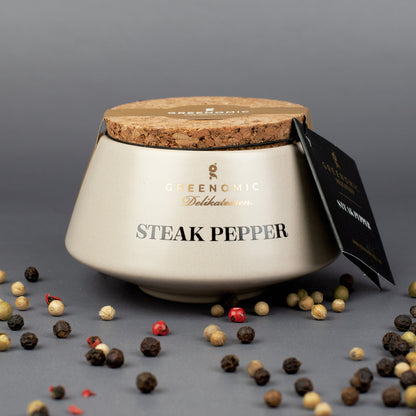 Greenomic Steak Pepper im Keramiktopf mit Korkdeckel und Pfefferkörnern auf dunklem Hintergrund