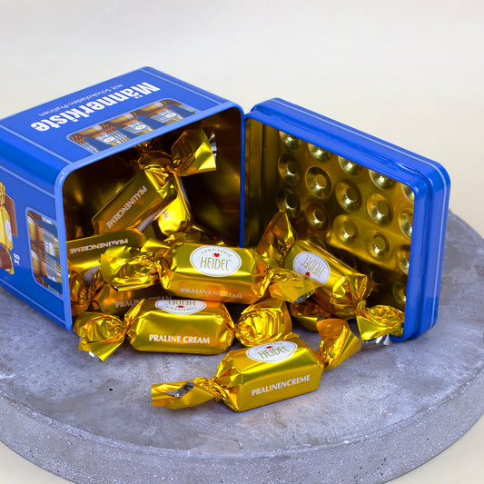 Geöffnete blaue Männerkiste mit goldverpackten Schokoladen-Pralinen