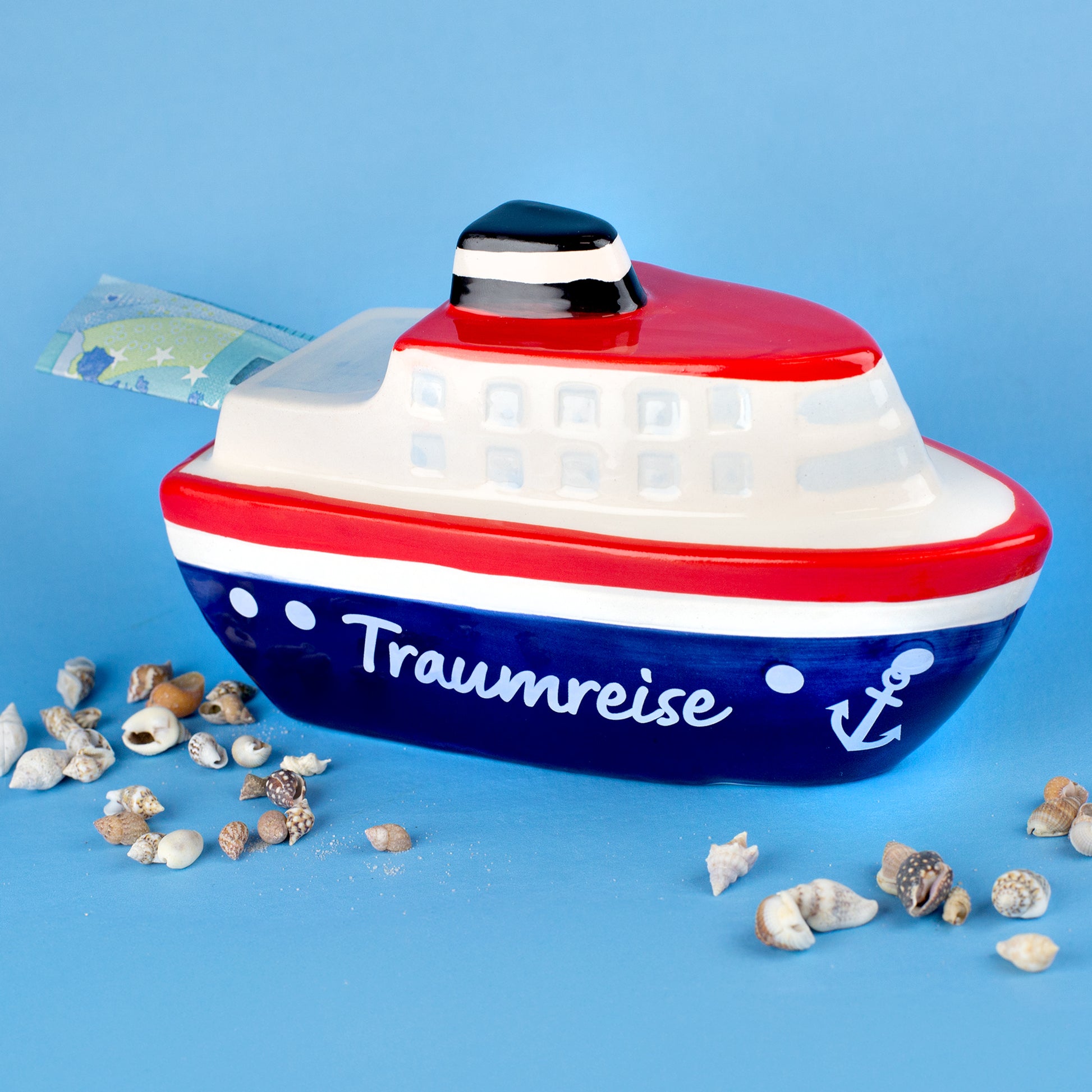 Spardose Schiff Traumreise mit rotem, blauem und weißem Design, seitlich mit Geldschein