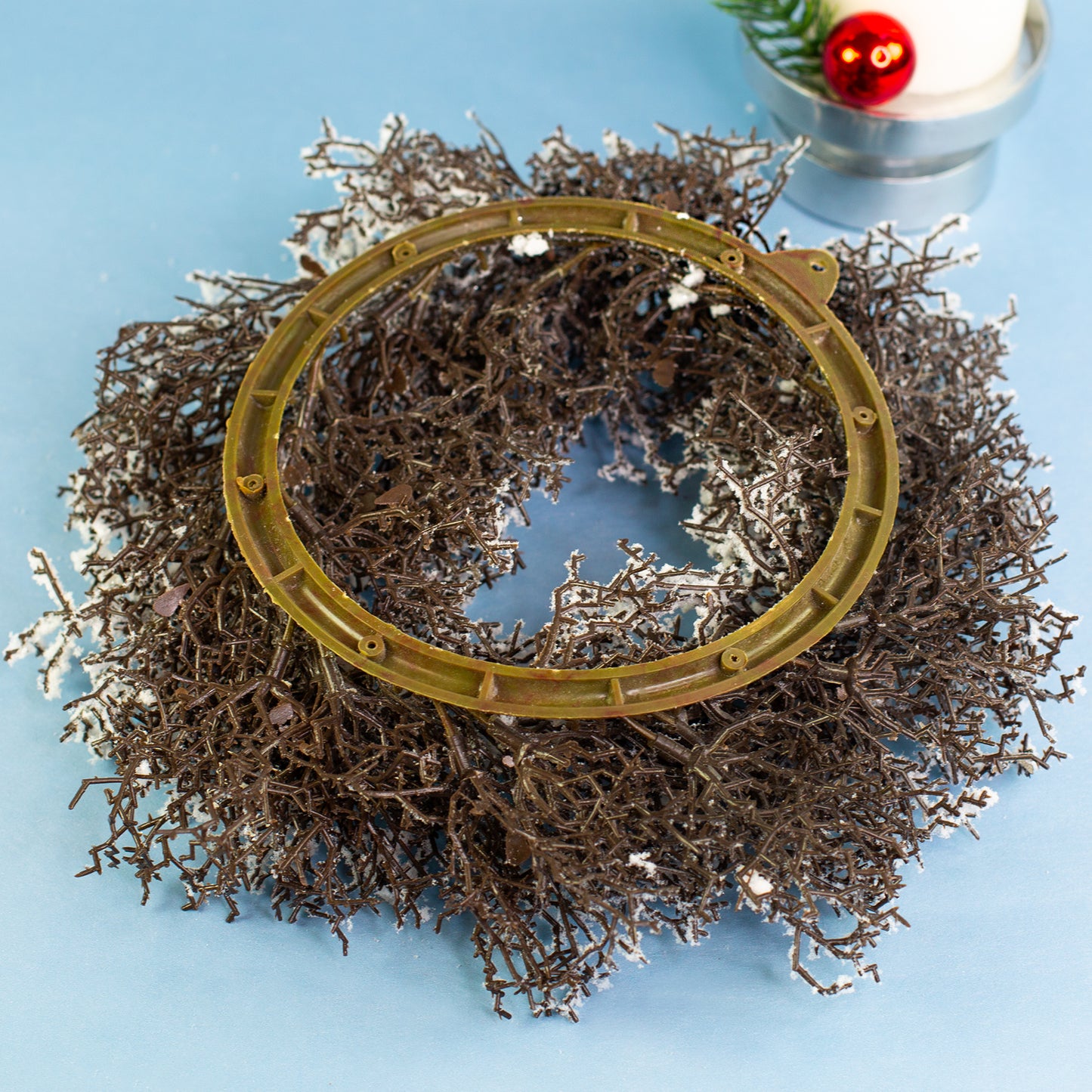 Rückseite des verschneiten Adventskranzes mit Aufhängeöse für Wand- oder Türdekoration