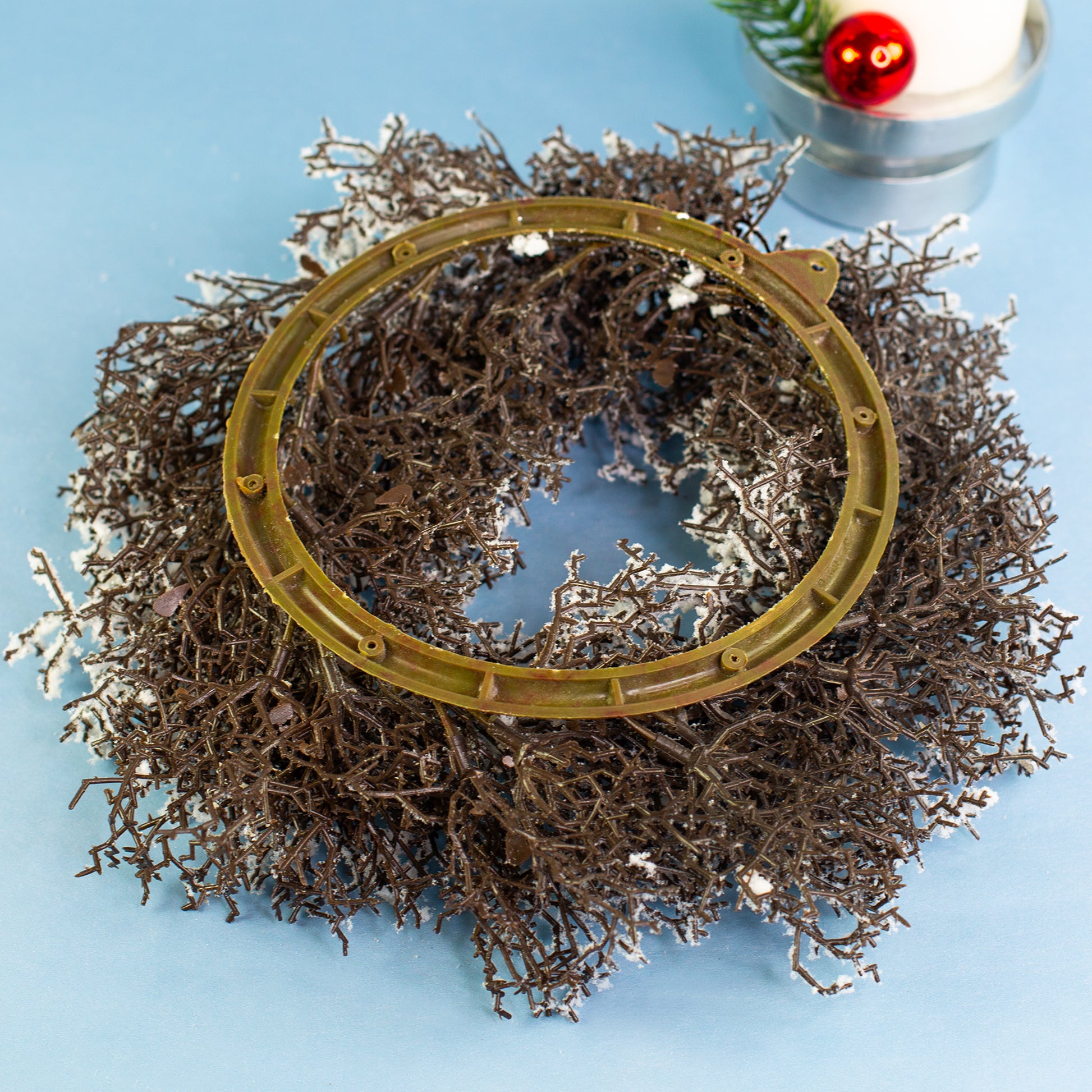 Rückseite des verschneiten Adventskranzes mit Aufhängeöse für Wand- oder Türdekoration