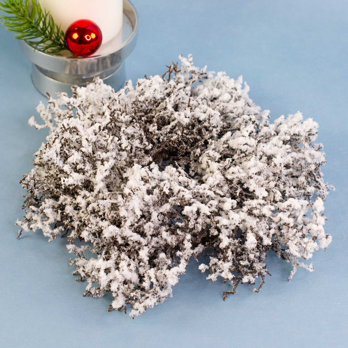 Kleiner künstlicher Adventskranz aus Schneezweigen mit realistischem Schnee-Effekt – ideal als Tischdeko oder Kerzenständer.