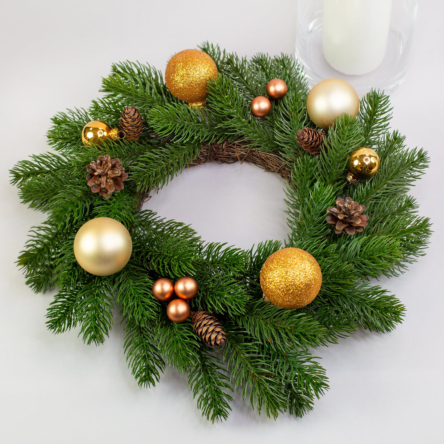 Kunst-Tannenkranz Ø 35 cm mit goldener Weihnachtsdeko und Kugeln auf Tisch