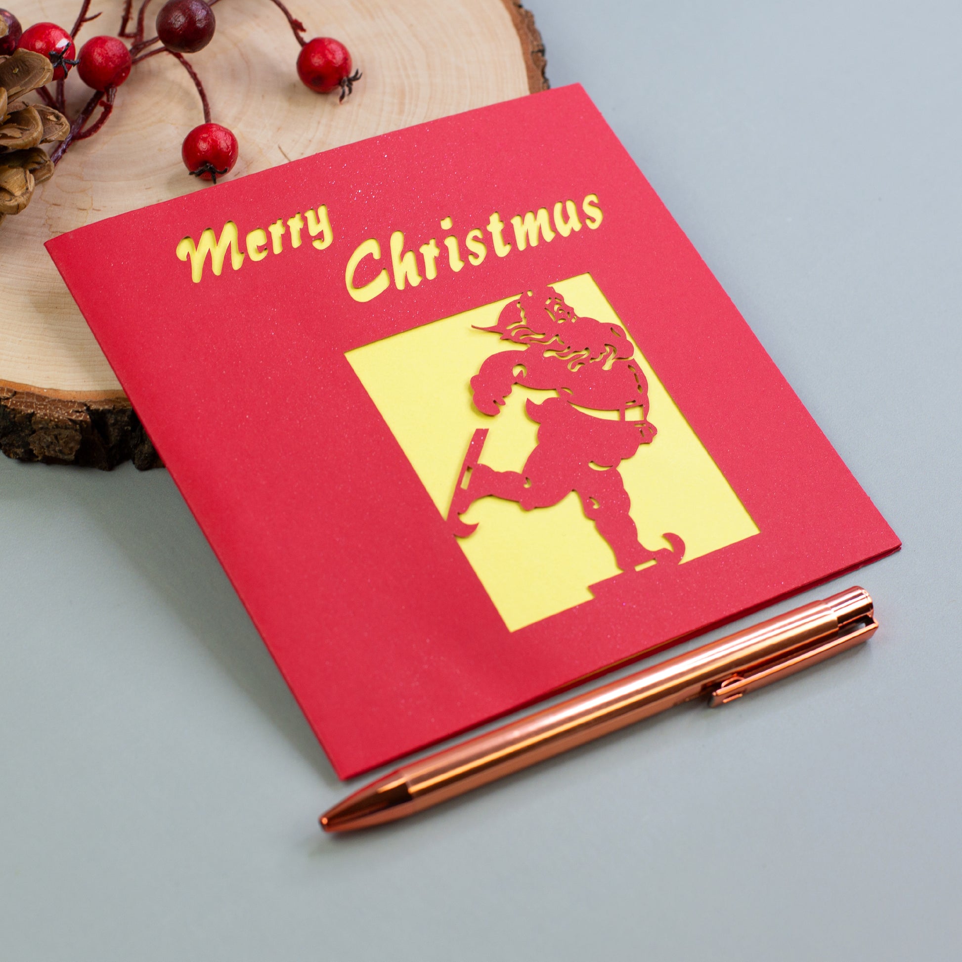 Rote Weihnachtskarte mit gelbem Innenfeld und „Merry Christmas“-Schriftzug, Motiv Weihnachtsmann auf Schlittschuhen.