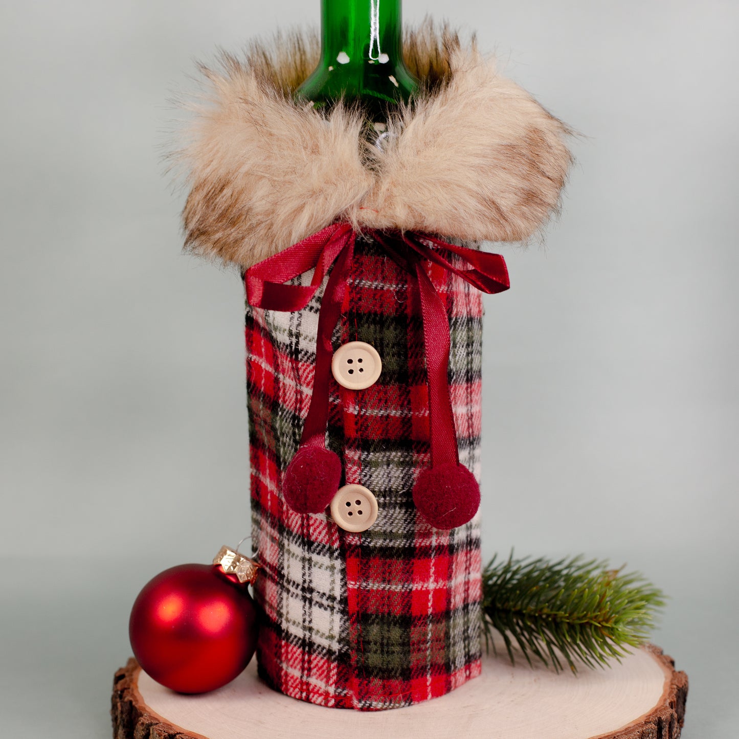 Nahaufnahme der karierten Flaschenverpackung mit Pelzkragen, Schleife und Knopfleiste.