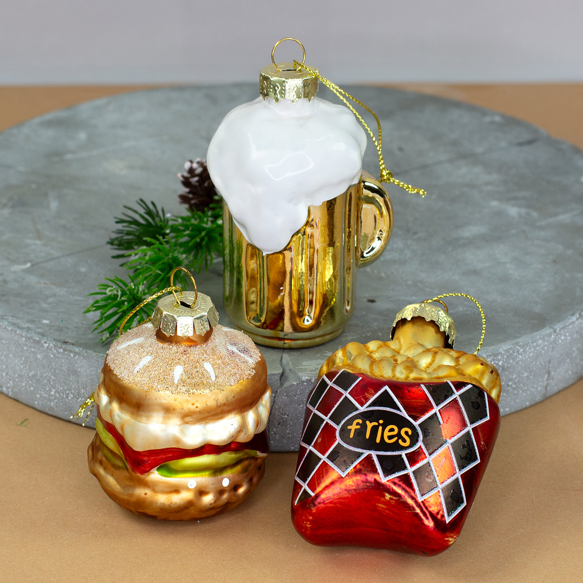 Glas-Baumschmuck 3er Set mit Burger, goldenem Bierkrug und roter Pommesverpackung nebeneinander