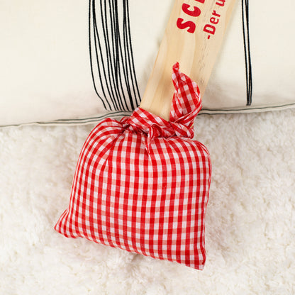 Nahaufnahme des gepolsterten Stoffkissens im rot-weißen Karomuster, weich verarbeitet