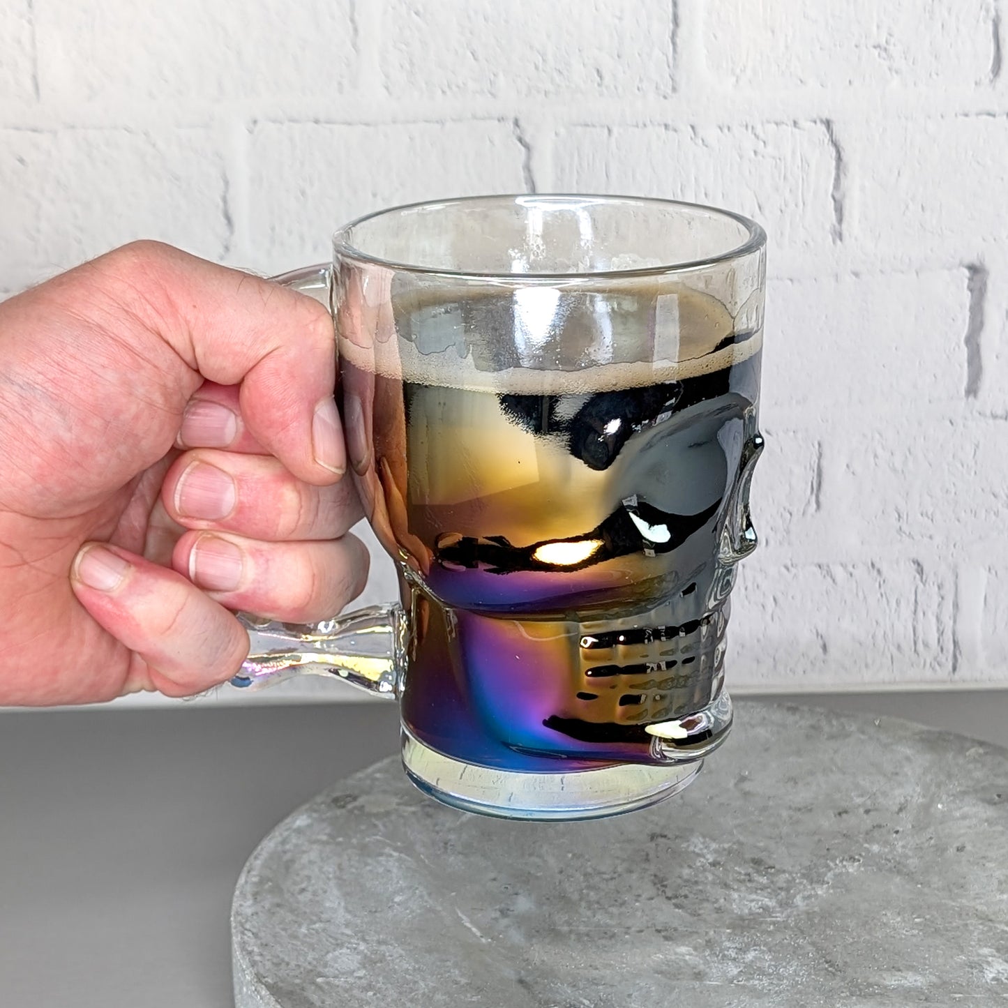 Totenkopfglas gefüllt mit Bier wird in der Hand gehalten