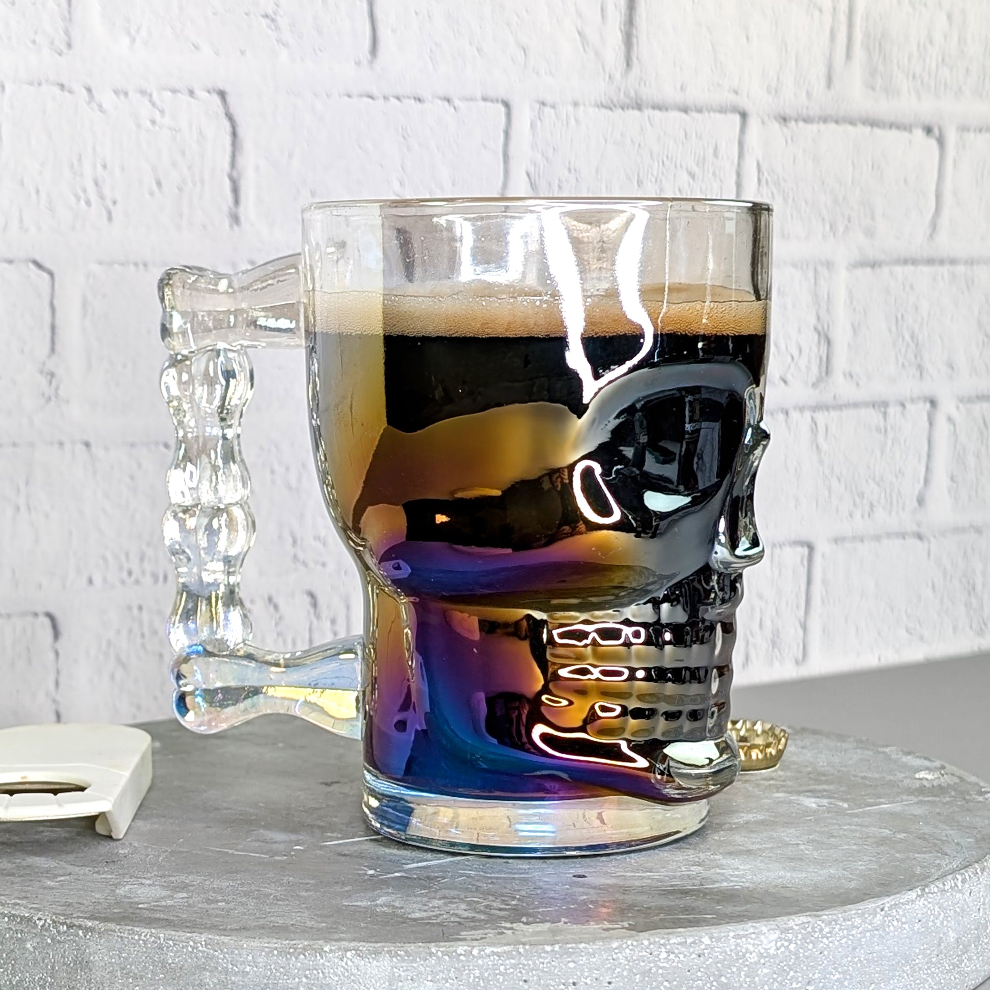 Seitliche Ansicht des gefüllten Glases mit sichtbarem Totenkopf-Relief und irisierendem Effekt