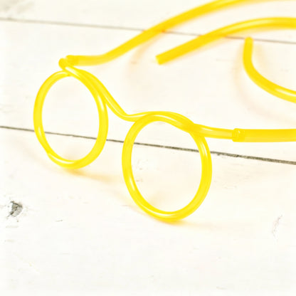 Gelbe Trinkschlauch-Brille – Nahaufnahme der Schlauchführung und Brillenringe auf hellem Untergrund