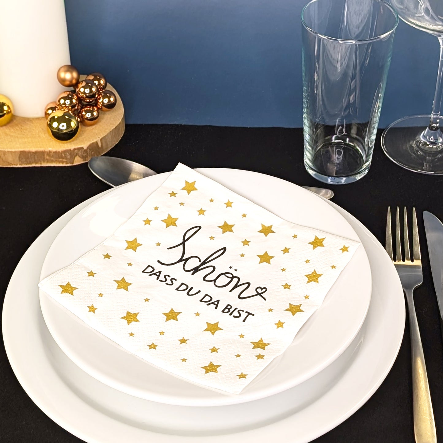 Servietten im festlichen Arrangement auf gedecktem Tisch mit Weihnachtsdeko.