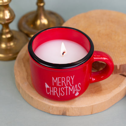 Brennende Kerze in roter Dolomitetasse Merry Christmas, festlich dekoriert