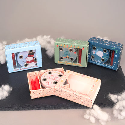 Vier Varianten des Mini-Adventskranzes in Metalldose mit unterschiedlichen Motiven auf einer Schiefertafel