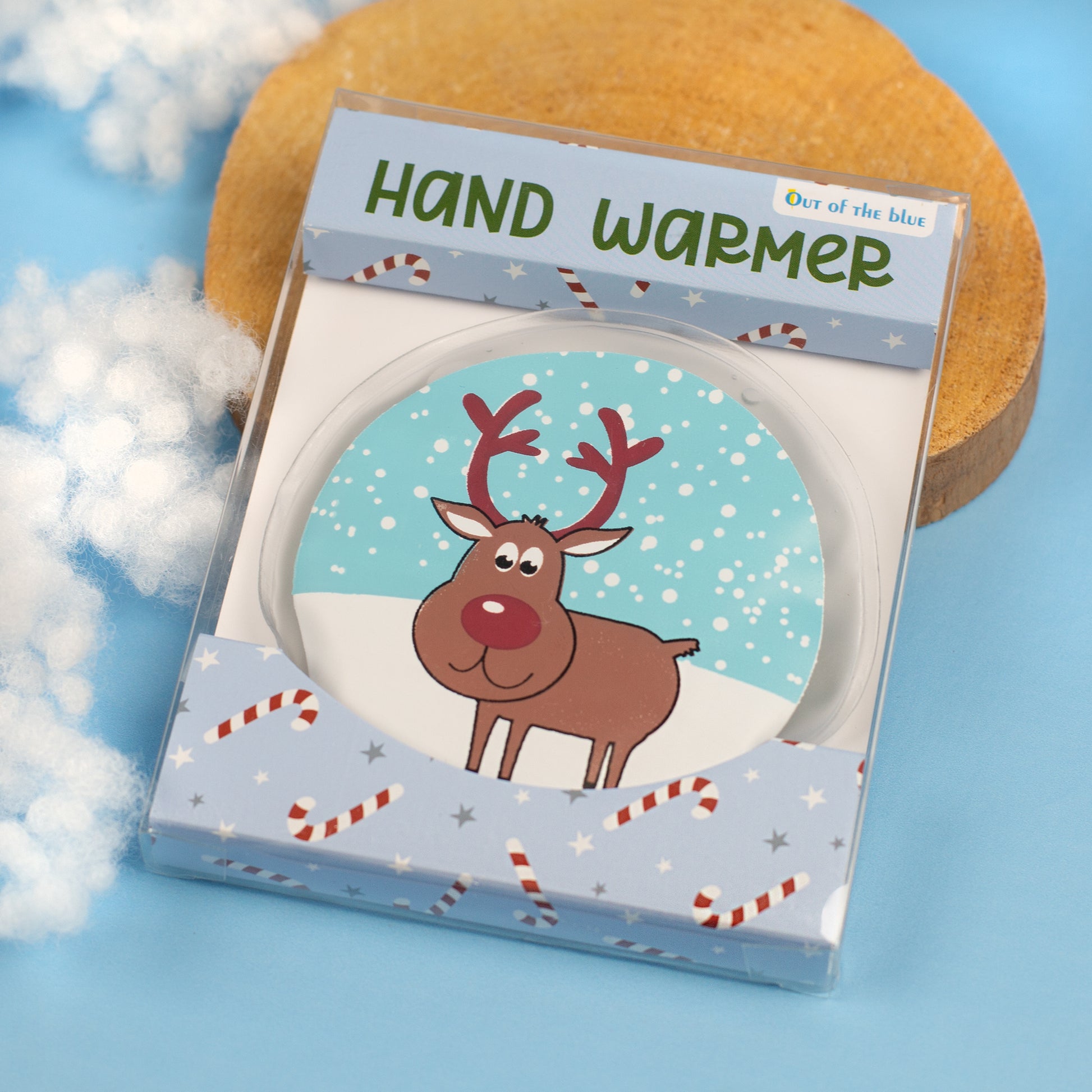 Runder Handwärmer mit Rentiermotiv in Geschenkverpackung auf winterlicher Deko