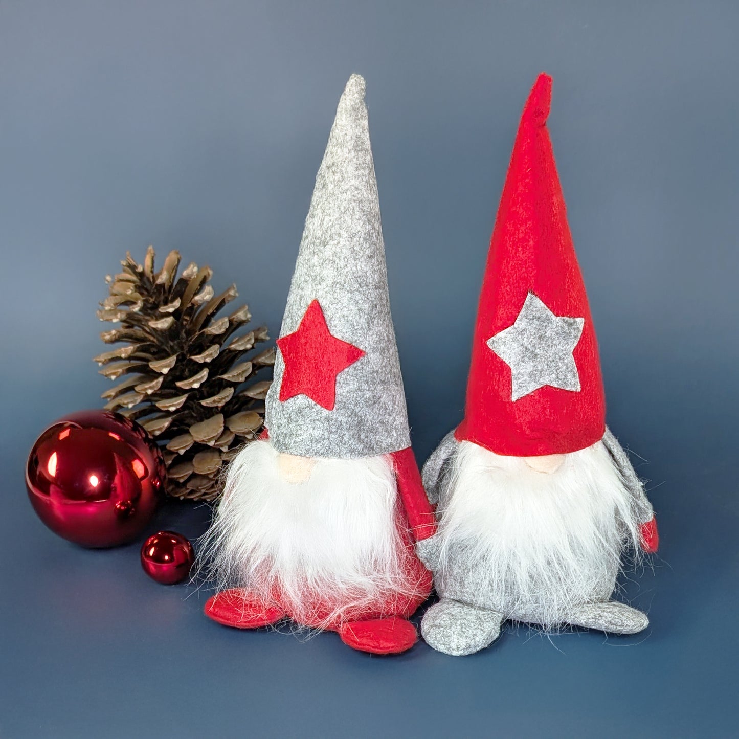 Zwei Weihnachtswichtel aus Filz mit Sternmützen in Rot und Grau als weihnachtliche Dekoration