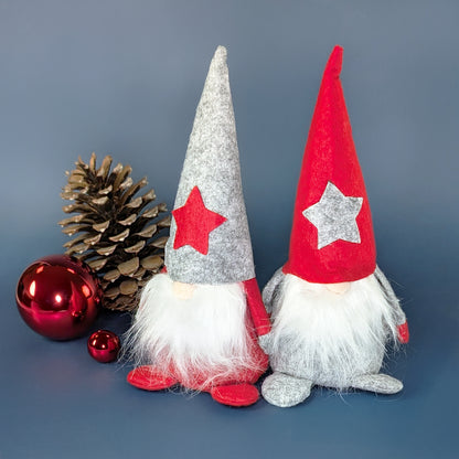 Zwei Weihnachtswichtel aus Filz mit Sternmützen in Rot und Grau als weihnachtliche Dekoration