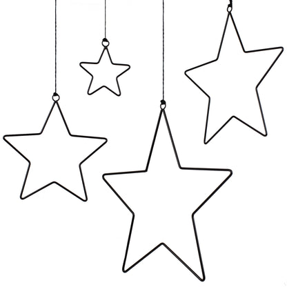 Vier schwarze Metallsterne in unterschiedlichen Größen hängen an feinen Schnüren vor weißem Hintergrund. Die minimalistischen Sternrahmen wirken elegant und leicht.