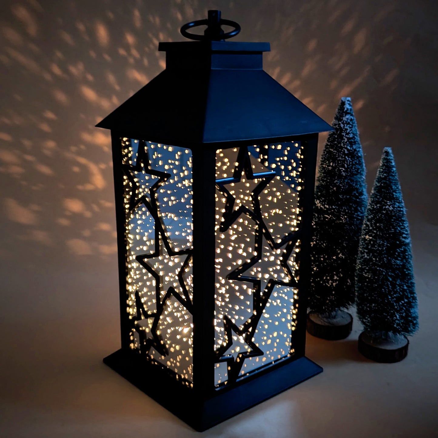Leuchtende LED-Laterne mit funkelndem Sternenmuster im Dunkeln mit Lichteffekt