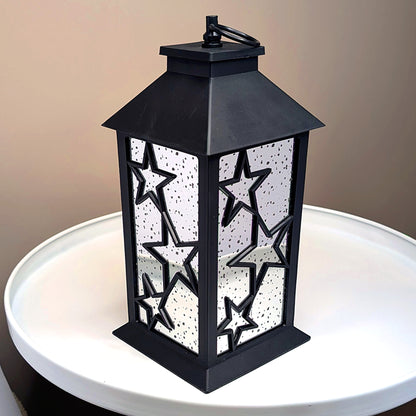 LED-Weihnachtslaterne mit Spiegelwänden und Sternendesign auf weißem Tisch