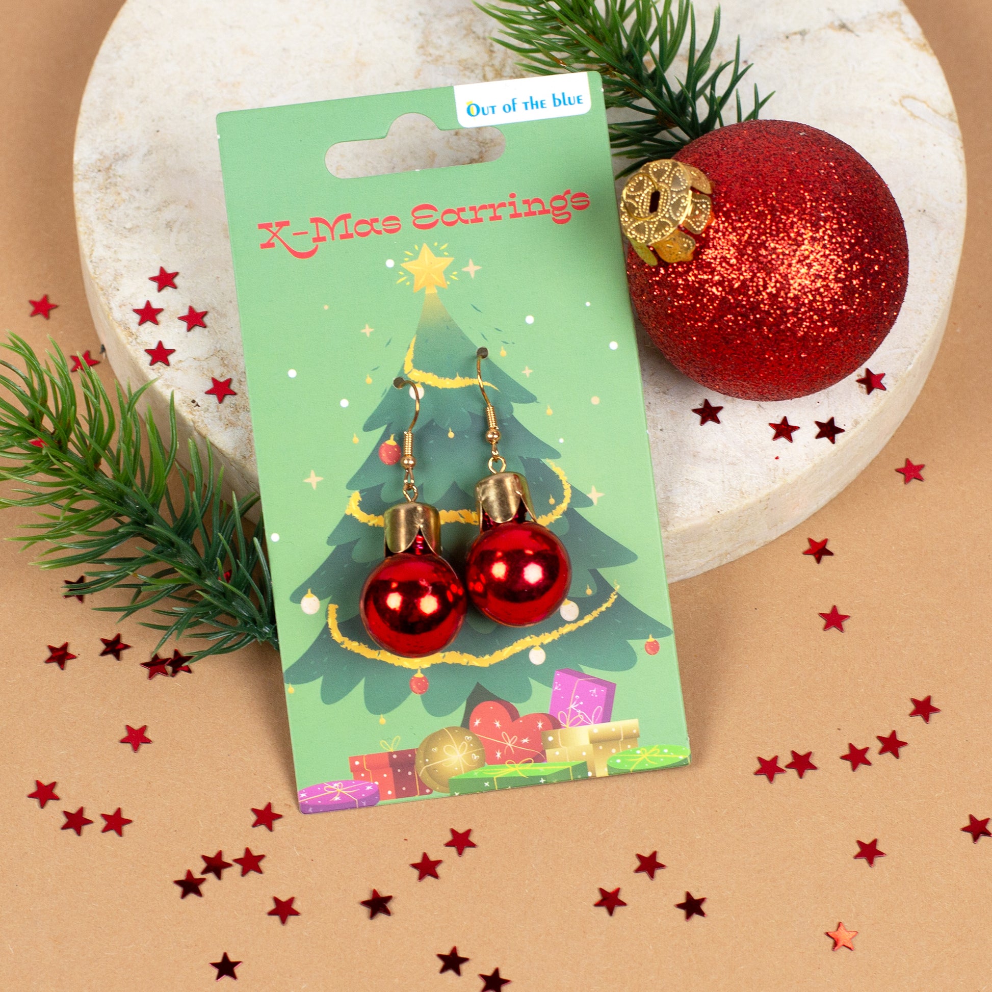 Rote Weihnachtskugel-Ohrringe dekorativ präsentiert neben roten Christbaumkugeln