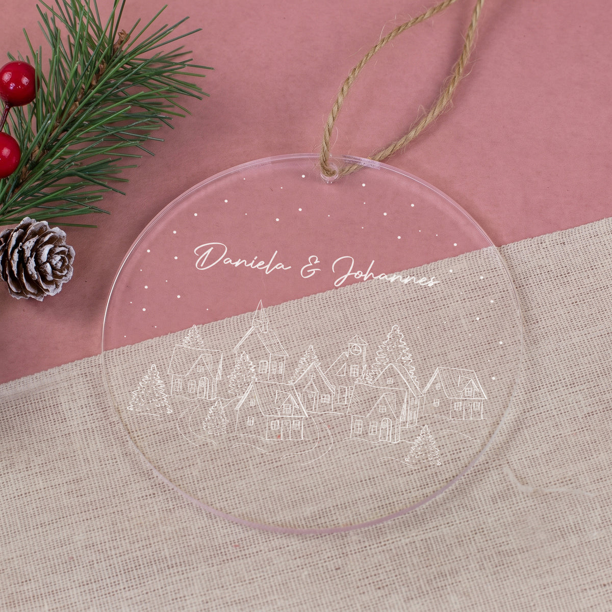 Personalisierter runder Weihnachtsbaumanhänger mit Namen Daniela & Johannes, Winterdorf und Schneepunkten