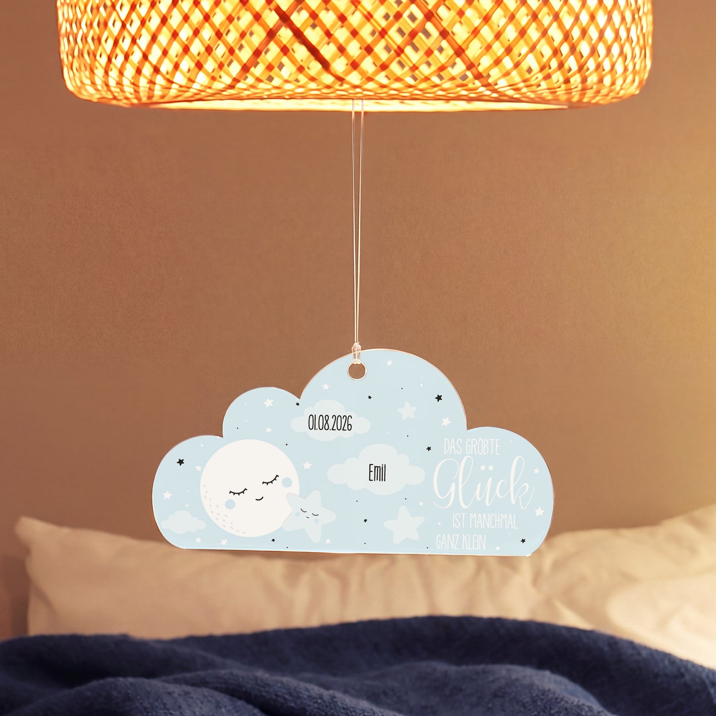 Personalisierter Acryl Wolken Anhänger zur Geburt eines Jungen mit Name Emil und Datum unter einer Lampe im Babyzimmer