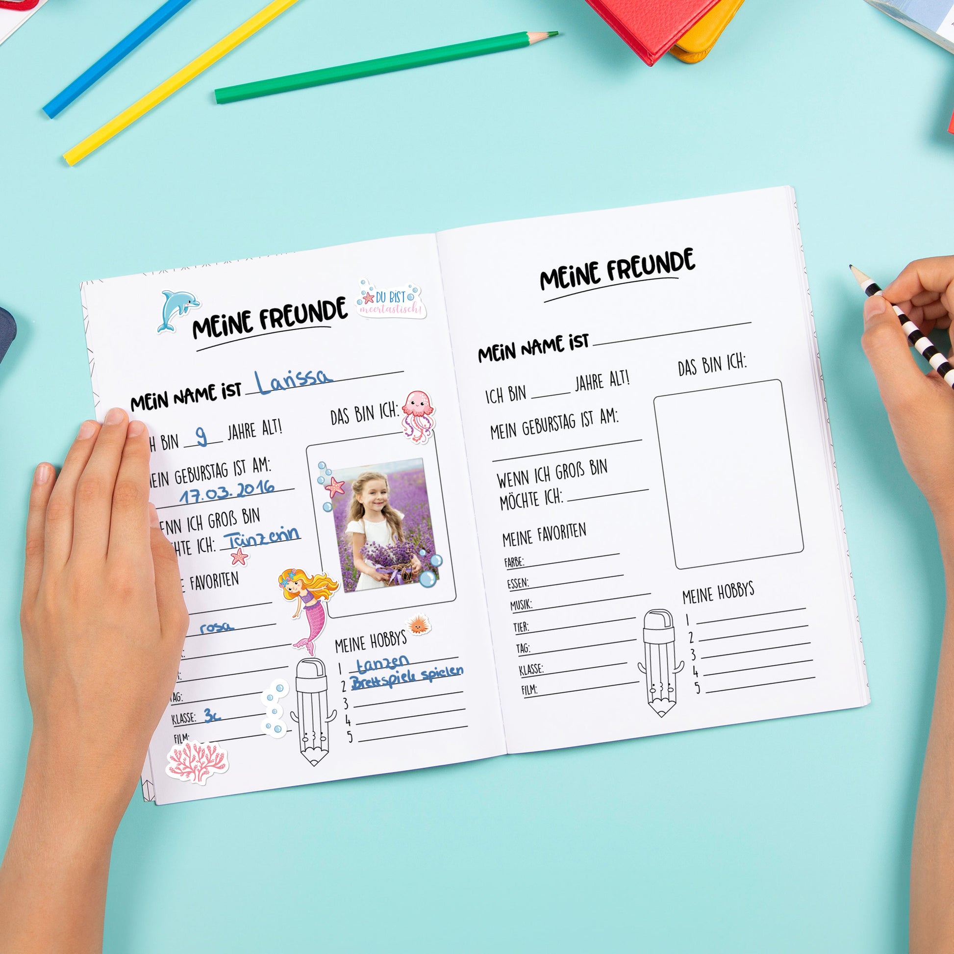 Aufgeschlagenes Freundebuch mit ausgefüllter Seite und Stickern mit Meerjungfrauen und Oktopus