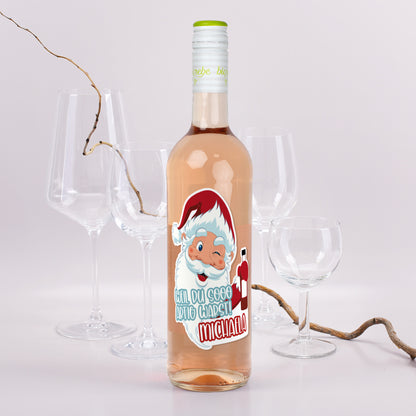 Roséweinflasche mit Weihnachtsmann-Etikett „Weil du sooo artig warst! Michaela“, dekoriert mit Gläsern und Zweigen.
