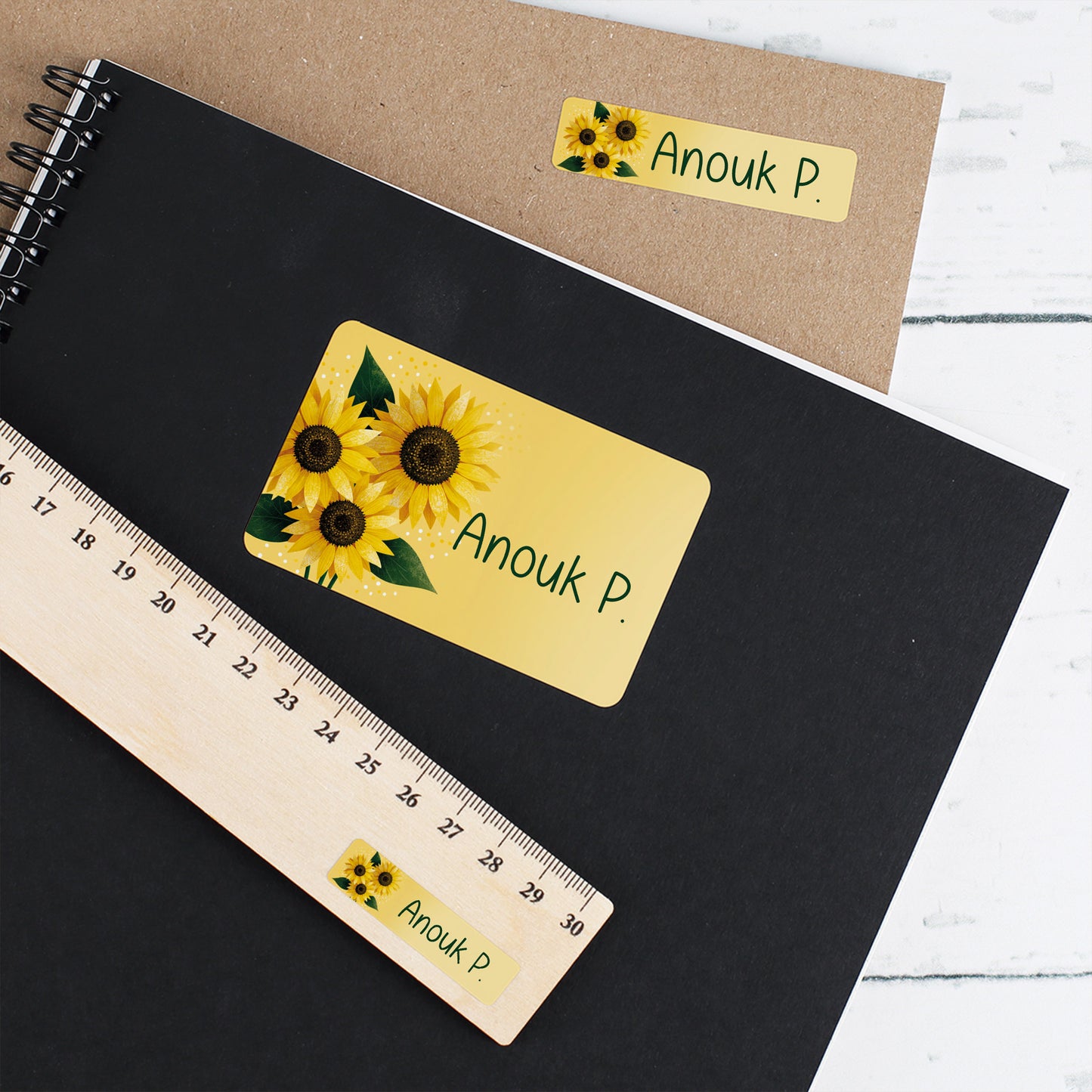 Namensaufkleber mit Sonnenblumen und Name Anouk P. auf Heft, Umschlag und Lineal