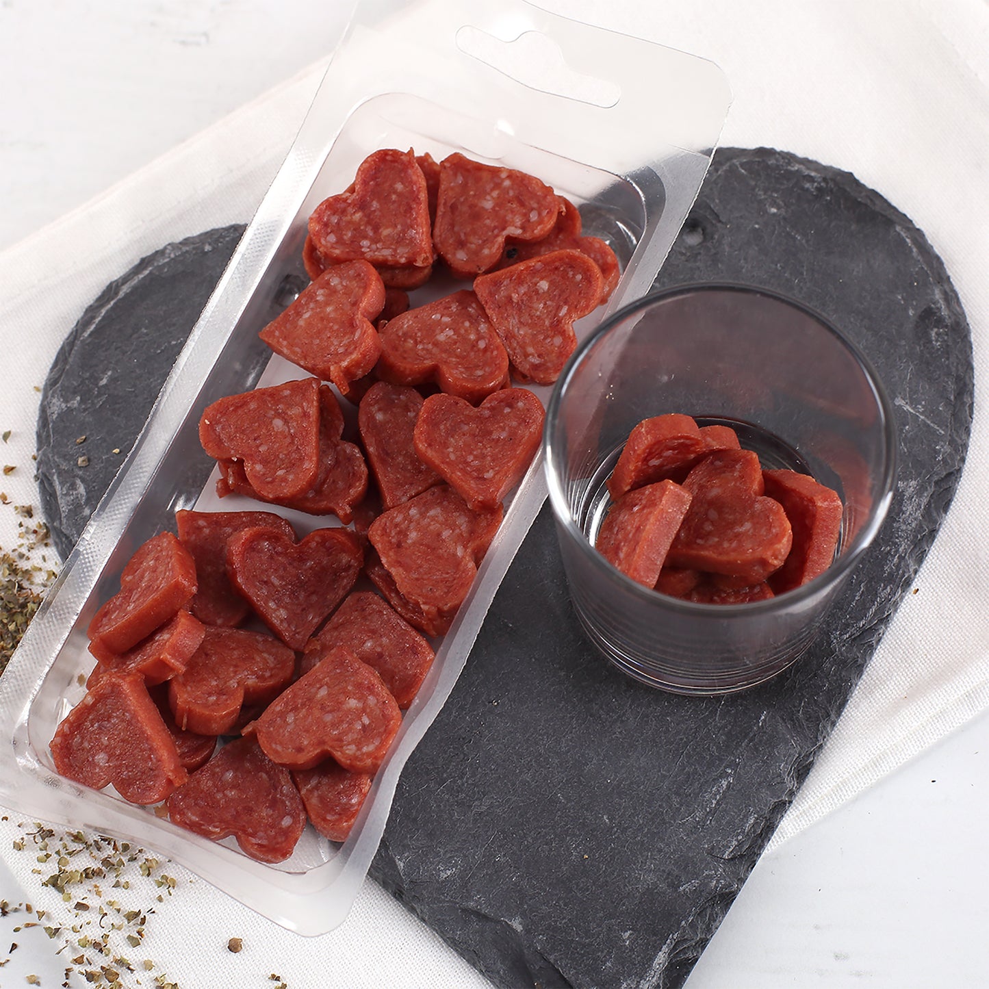 Offene Packung mit herzförmigen Mini-Salami-Pralinen als herzhafter Snack zu Weihnachten.