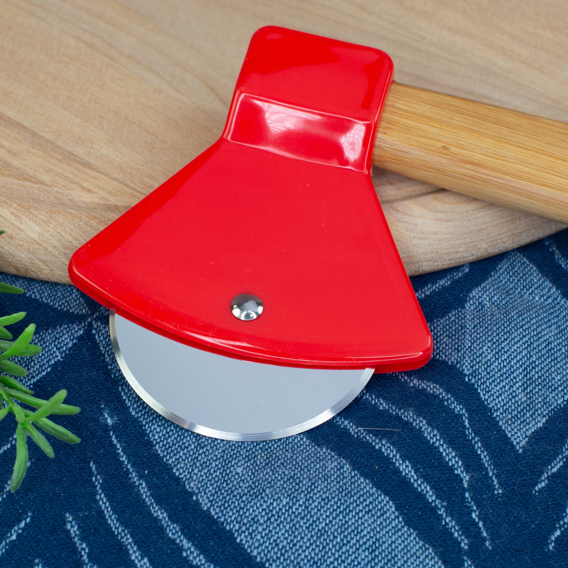 Detailaufnahme des Pizzaschneiders in Feuerwehr-Axtform mit Edelstahlrad