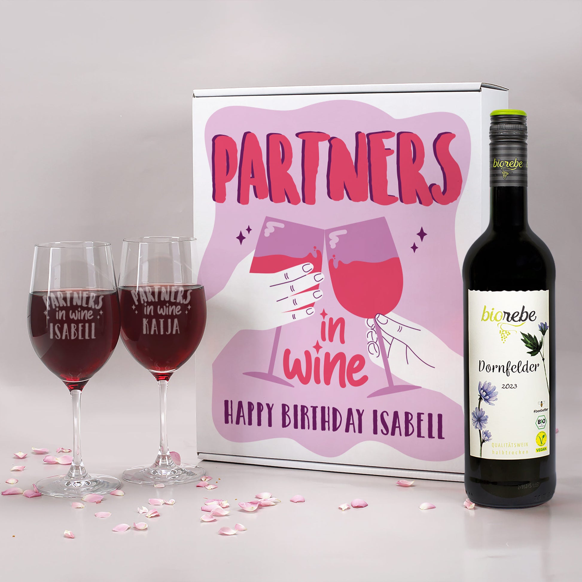 Geschenkset mit Biorebe Dornfelder, zwei gravierten Weingläsern mit „Partners in Wine“ und Geschenkbox mit rosafarbenem Motiv und Aufschrift