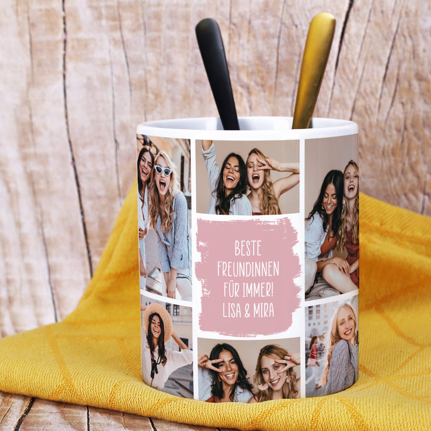 Nahaufnahme der Fototasse mit mehreren Bildern von zwei Freundinnen und einem farbigen Textfeld in Rosa mit der Aufschrift „Beste Freundinnen für immer! Lisa & Mira“. Die Tasse steht vor einem gelben Handtuch, darin zwei Teelöffel in Schwarz und Gold.
