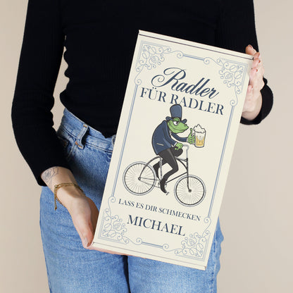Personalisierte Geschenkbox „Radler für Radler“ mit Name und Wunschtext, in der Hand gehalten