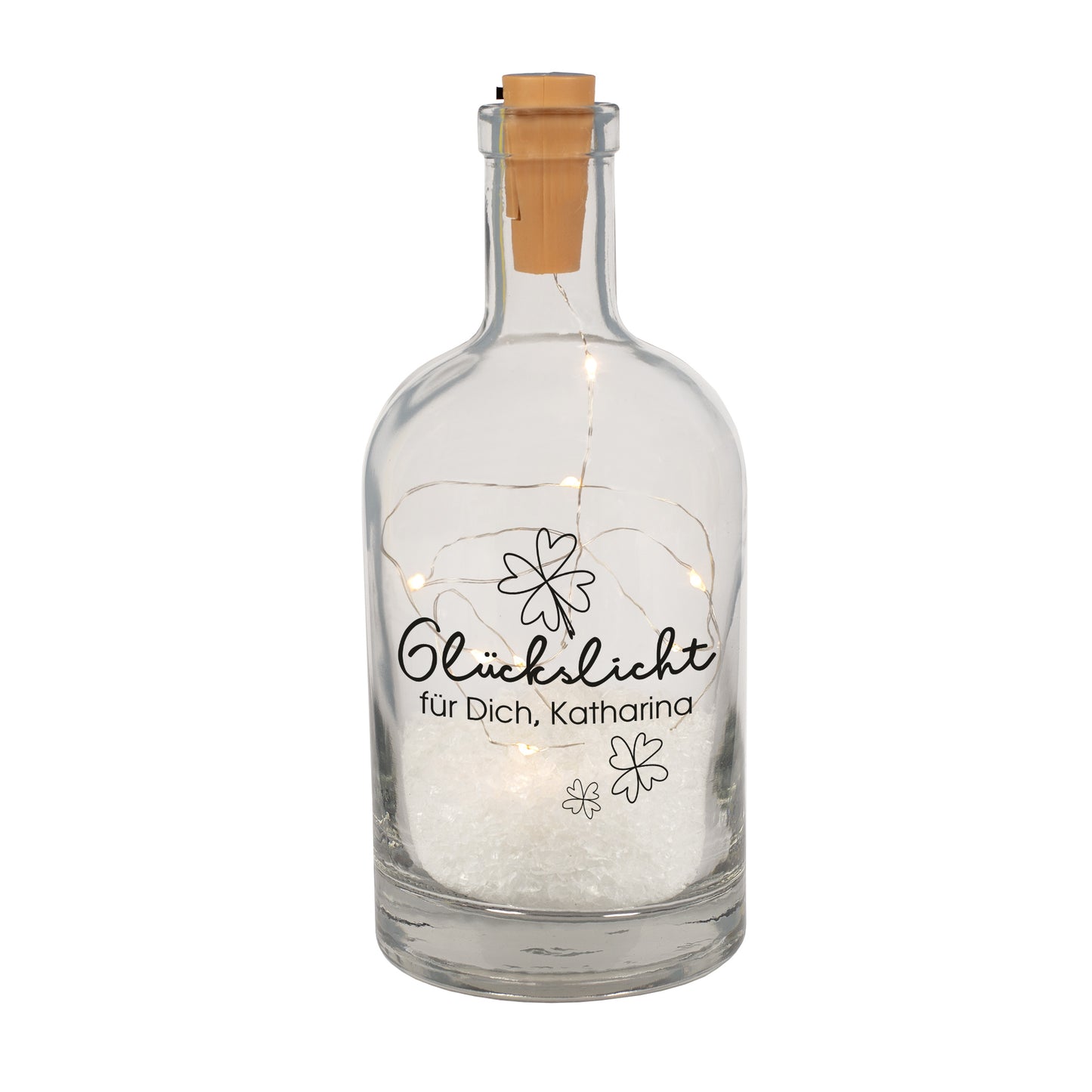 Freigestellte Glückslicht-Deko-Karaffe aus Glas mit Kleeblattmotiv, Wunschtext und integrierter LED-Lichterkette, dekoriert mit Kunstschnee.