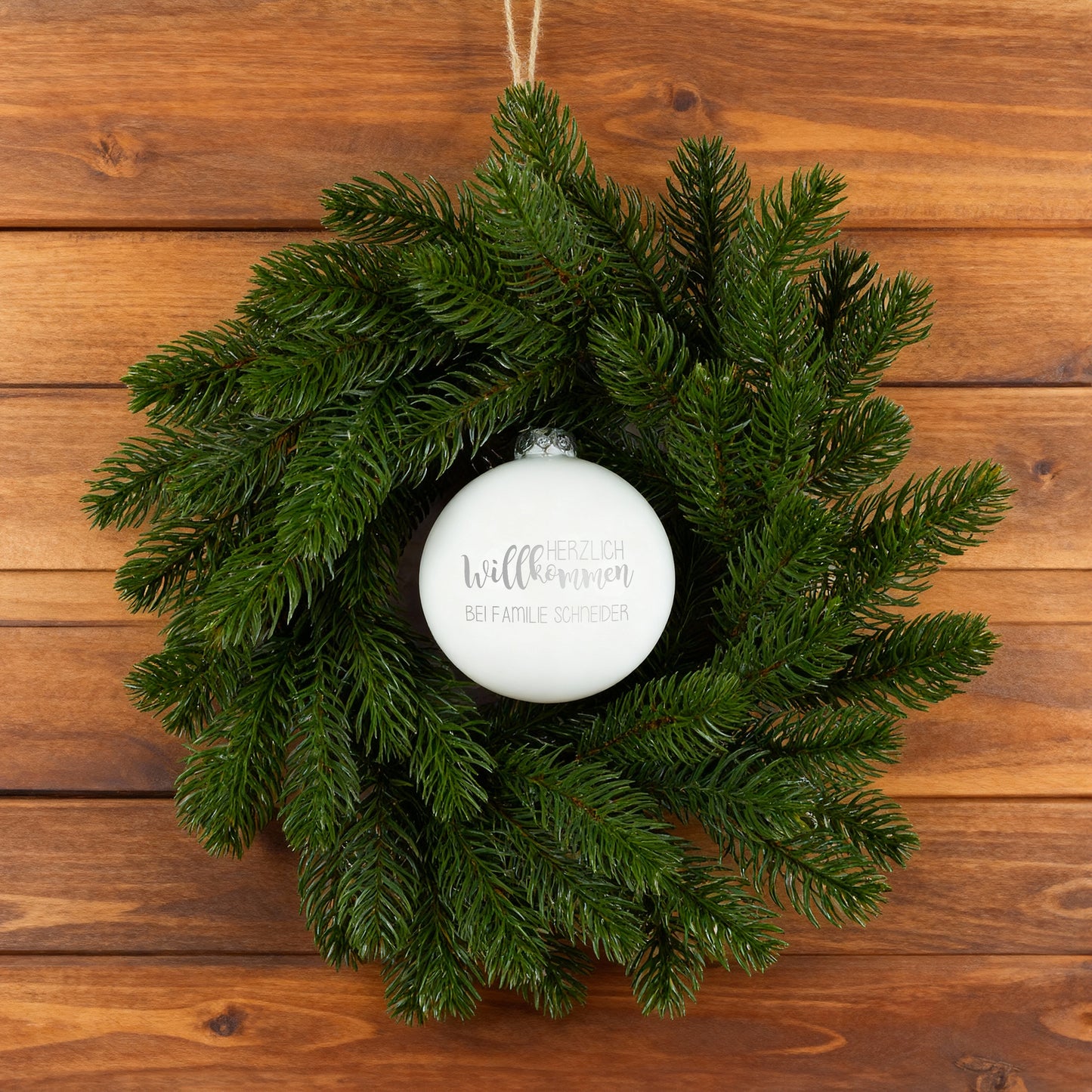 Türkranz mit weißer gravierter Willkommens-Kugel auf Holzuntergrund