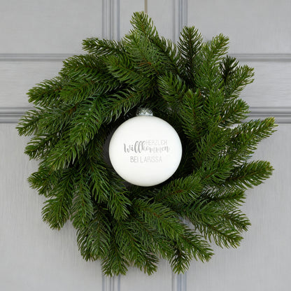 Türkranz mit weißer Willkommens-Kugel an grauer Haustür dekoriert