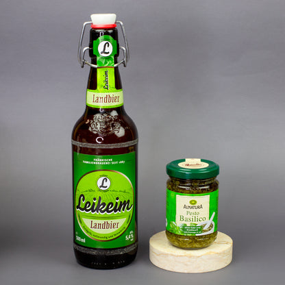 Leikeim Landbier mit Alnatura Pesto Basilico auf grauem Hintergrund