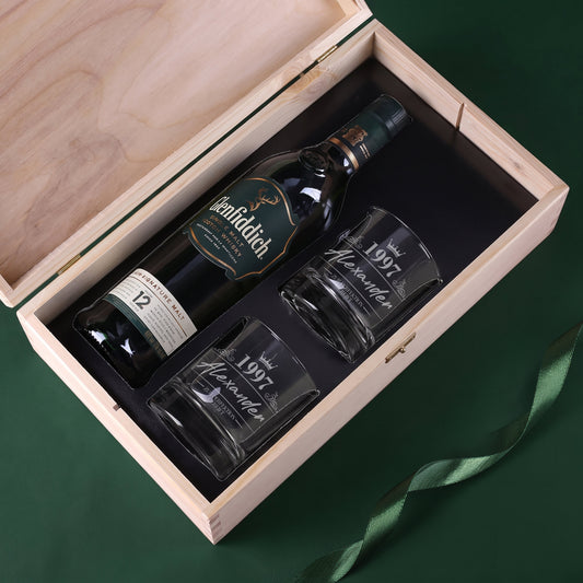 Offene Holzkiste mit Glenfiddich Whiskyflasche und zwei gravierten Whiskygläsern im schwarzen Inlay
