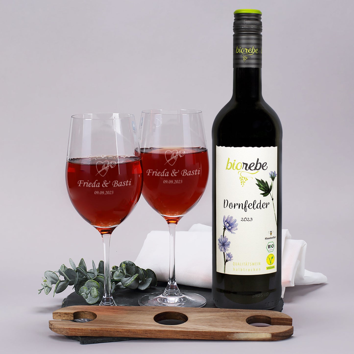 Weingläser mit Gravur „Frieda & Basti – 09.09.2023“, dazu Biorebe Dornfelder Rotwein und Holz-Weinbutler