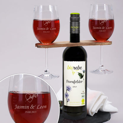 Personalisierte Weingläser mit Gravur „Jasmin & Leon – 19.08.2023“ und Herzmotiv, zusammen mit Biorebe Dornfelder Rotwein und Holz-Weinbutler