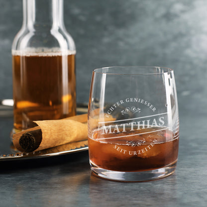 Personalisiertes Whiskyglas mit Aufdruck „Echter Genießer Matthias – Seit Urzeiten“, gefüllt mit Whisky neben Zigarre und Whiskyflasche