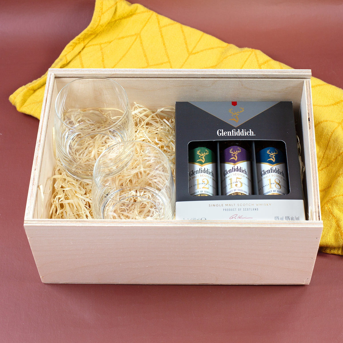 Geöffnete Holzbox mit Whiskygläsern und Glenfiddich Miniaturflaschen als Geschenkset für Whisky-Liebhaber