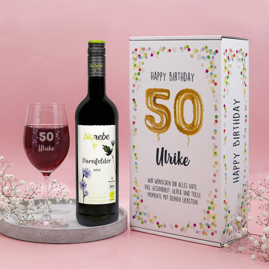 Geschenkset mit Biorebe Dornfelder, graviertem Leonardo-Weinglas „Happy Birthday 50 Ulrike“ und weißer Geburtstagsbox mit goldenen Ballon-Zahlen und Konfetti-Design.