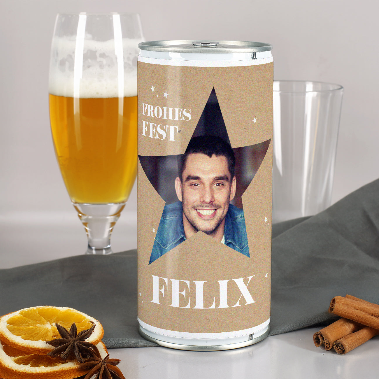 Personalisierte Weihnachtsbierdose mit Sternmotiv, Foto eines Mannes und Name „Felix“, weihnachtlich dekoriert mit Gewürzen und Bierglas im Hintergrund.